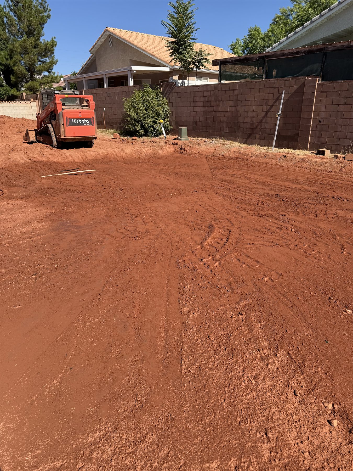 Finished building pad graded smooth with compacted red dirt